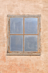 Blank old window on rough plastered wall