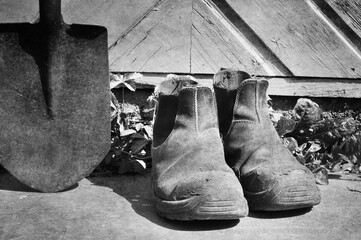 Workers boots with old spade in black and white