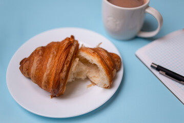 Notebook, pen, glasses and croissant. Morning girls, plans for the day