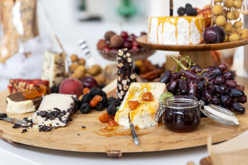 cheese board filled with cheeses and fruits