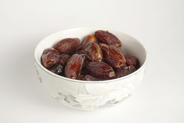 a bowl filled with a collection of dates with a plain white background