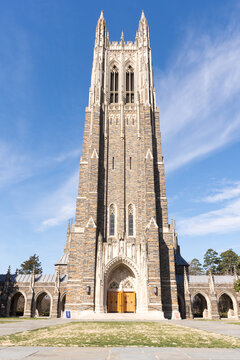 Exterior of Duke University Chapel, front view at slight angle. Durham, North Carolina, bright sunshine, blue sky, clouds.