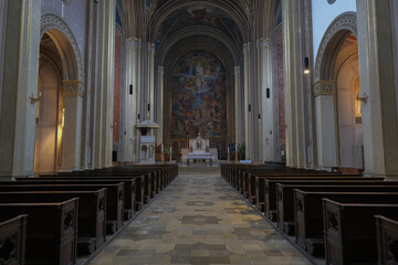 Monumental church building in Gothic in neo-romanesque arch style with large ceiling and altar murals and fresco, opulent detailed columns and marble structures