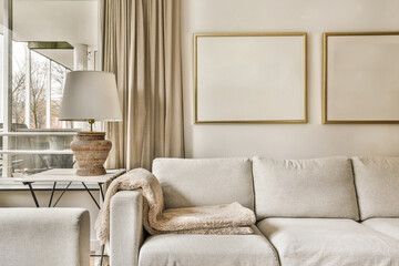 a living room with two couches and a coffee table in front of the sofa is framed by gold frames