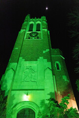 Beaumont Tower at night lit in green on the campus of Michigan State University in East Lansing, Michigan.
