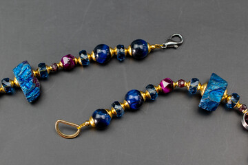 Fototapeta na wymiar Colorful gemstone crystal beads necklace on black, unique handmade jewelry background
