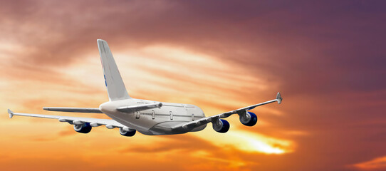 Commercial airplane flying above clouds in dramatic sunset light. Very high resolution of image.