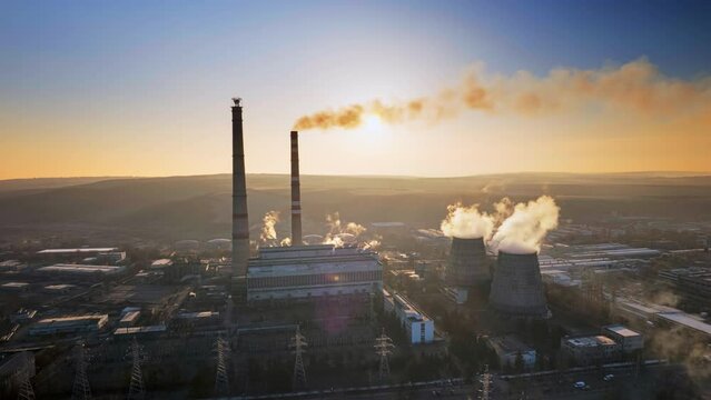 Aerial drone timelapse view of thermal power plant in Chisinau at sunrise, Moldova. View of pipes with felling steam, infrastructure around