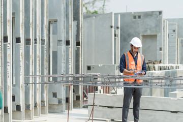 Male engineers are inspecting and controlling the work of the employees and the quality of the manufactured products to meet the standards In industrial factories producing precast prefabricated walls