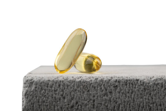 Yellow oil capsules with vitamin D isolated on white background. Omega 3 tablet. Healthy diet concept