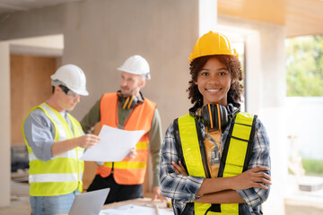 Architect colleagues mixed race working as a team discussing data working and tablet, laptop with on on architectural project at construction site at desk.