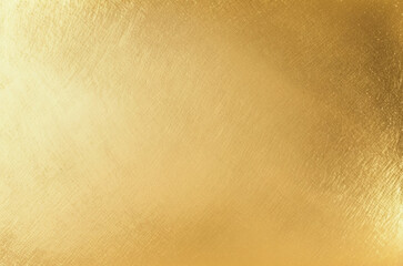 Shiny gold foil polished background with the reflection of golden light.