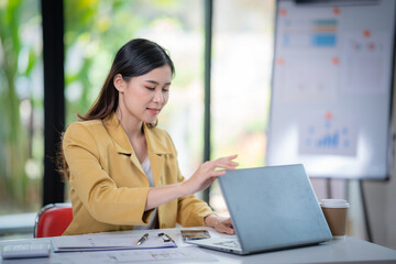 Happy businesswoman talking on mobile phone while analyzing weekly schedule in the office.