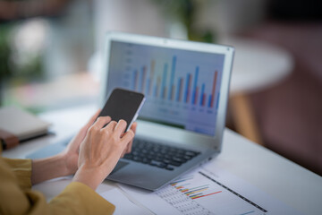 Happy businesswoman talking on mobile phone while analyzing weekly schedule in the office.