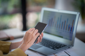 Happy businesswoman talking on mobile phone while analyzing weekly schedule in the office.