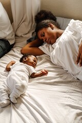 Young black mother together her newborn on the bed.