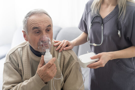 Sick elderly man makes inhalation.