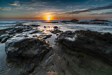 Sunset over rocks on the beach of Palmachim