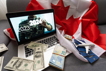 laptop with plane, money and canada flag