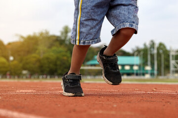 running forward on the treadmill of an Asian boy. the concept of outdoor play, outdoor activities, leisure activities, exercise. Soft and selective focus.