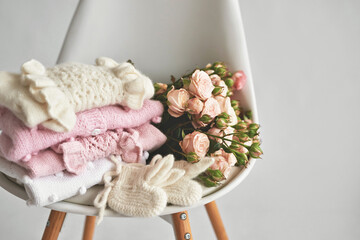Warm knitted clothes and flowers. Knitted clothes. Preparation for childbirth