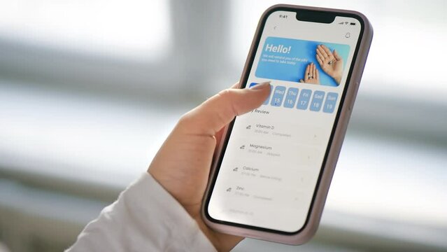 Close view of a person using smartphone with medication tracker app