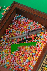 Fototapeta na wymiar Wooden gift box filled with colored foam balls