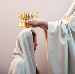 Hands placing a crown on a woman's head
