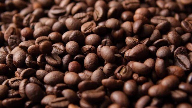 A pile of roasted coffee beans is spinning around. Close-up view. Ingredients in beverage preparation and beauty cosmetics