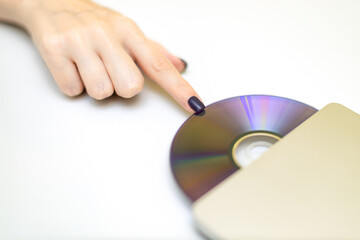 woman inserting a laser disc into a disk drive.