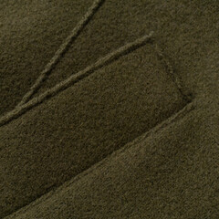 Detail of a pocket of a green woolen coat close up