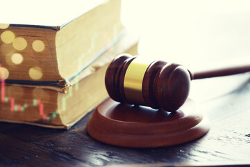Wooden judge gavel and legal book on wooden table