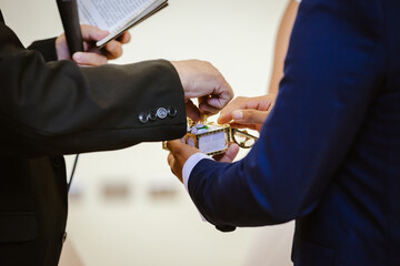 Pastor toma los anillos de boda de los novios