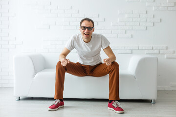 Fototapeta premium Portrait of the young man in white on sofa.