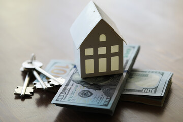 Model of cardboard house with key and dollar bills. Building, loan, real estate, cost of housing or buying a new home concept.