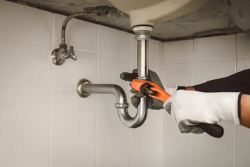 plumber at work in a bathroom, plumbing repair service , fix water plumbing leaks, replace the...
