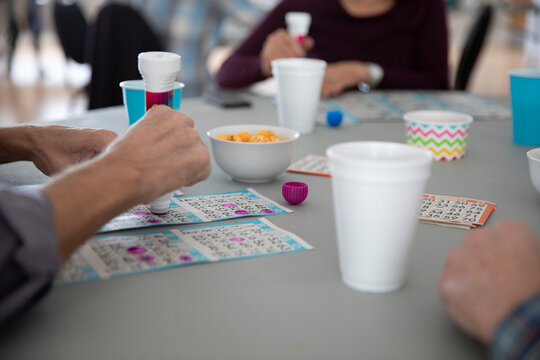 Senior Man Playing Bingo In Community Hall