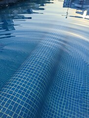 Reflections in water at pool with sunset light