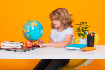 Kid boy from elementary school with book on yellow isolated background. Little student, smart nerd...