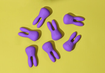 Top view of many violet dildo vibrators for clitoris on yellow background. Sex toys for adult