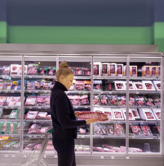 Woman choosing a dairy products at supermarket.