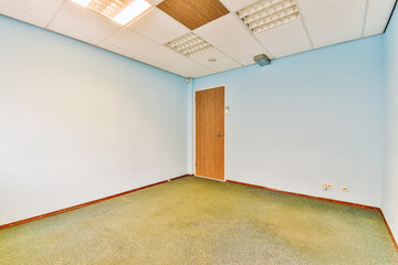 an empty room with blue walls and wood trim on the ceiling above it is a door that leads to another...