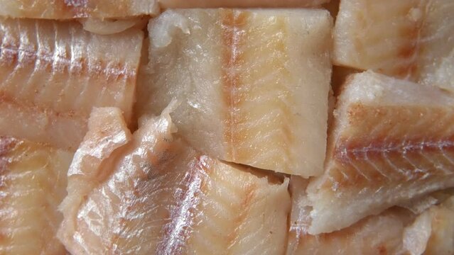 Raw fish fillet is spinning. Top view. Slices of fresh whitefish. Full frame. Sashimi rotation. Close up. Marine market. Video for sale. Cod, pollock loin steaks. Pangasius, tilapia pieces background.