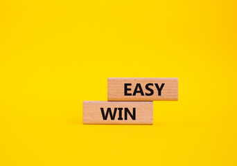 Easy win symbol. Wooden blocks with words Easy win. Beautiful yellow background. Business and 'Easy win' concept. Copy space.