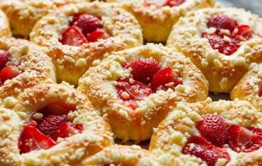 Homemade sweet yeast buns with the addition of strawberries and butter crumble, sprinkled with powdered sugar.