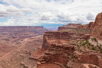Scenic view from Shafer Trail Viewpoint in Canyonlands National Park near Moab, Utah, USA. Shafer Basin and La Sal Mountains in  Colorado Plateau in distance. Off road trails leading down the canyon
