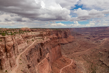 Scenic view from Shafer Trail Viewpoint in Canyonlands National Park near Moab, Utah, USA. Shafer Basin and La Sal Mountains in  Colorado Plateau in distance. Off road trails leading down the canyon