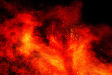 Red orange particles explosion on black background.Freeze motion of red orange dust splash.