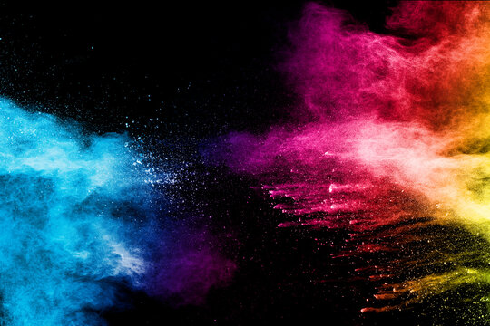 Explosion of colorful Holi powder on black background. Vibrant color dust particles textured background.