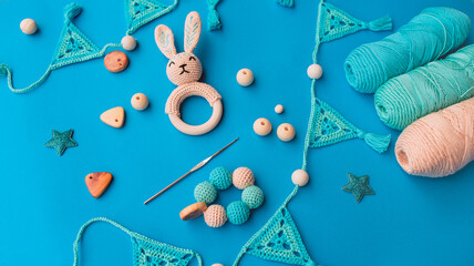Layout of crochet baby toys, crochet hook and skeins of yarn on